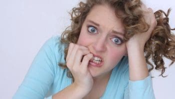 Nervous woman biting nails.