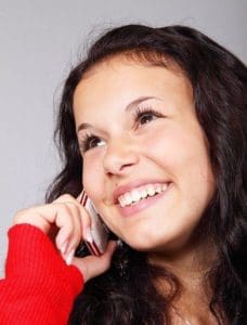 Girl smiling talking on phone.