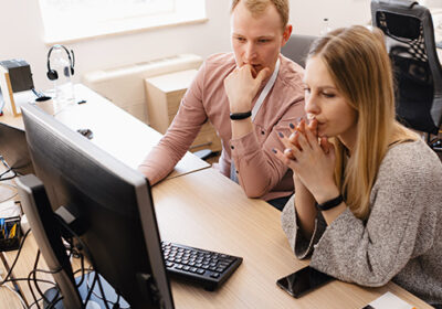 Two people working in front of a computer
