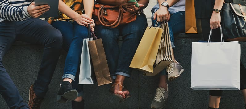 People shopping at retail stores with bags
